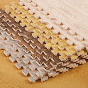BabiePlay Wood Grain EVA Foam Puzzle Play Mat Tiles in multiple wood colors stacked on wooden floor