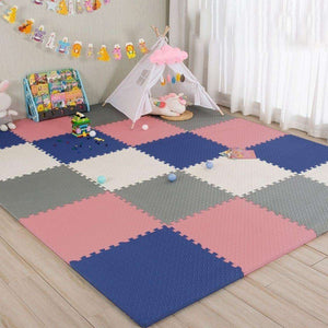 Interlocking pink, blue, gray, and white baby foam play mats in a nursery with a play tent and books.