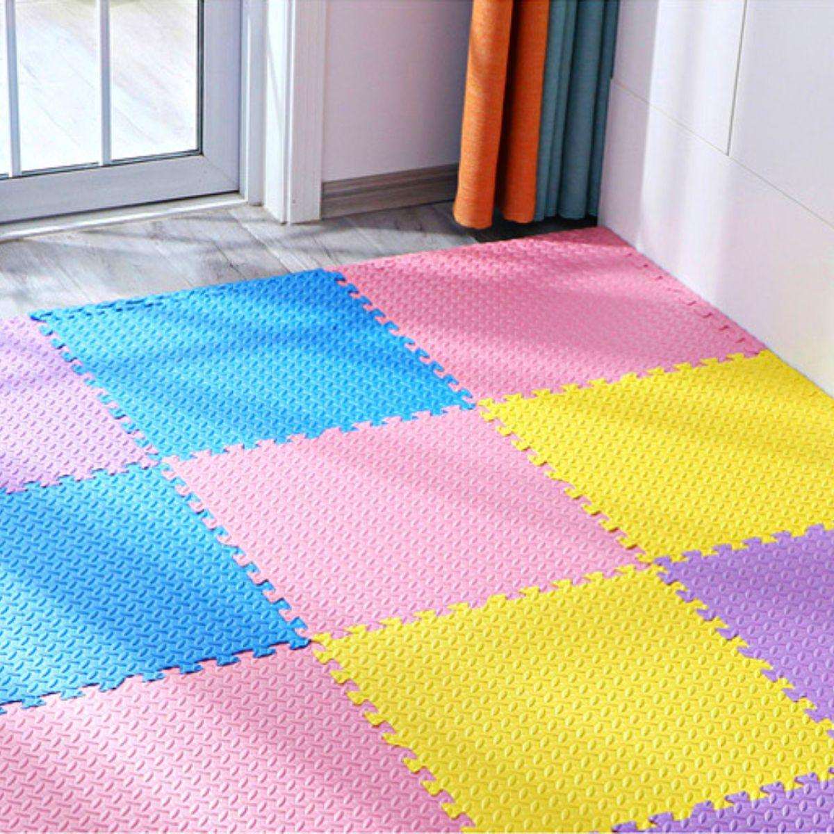 Interlocking colorful baby foam play mats in pastel pink, blue, yellow, and purple on nursery floor