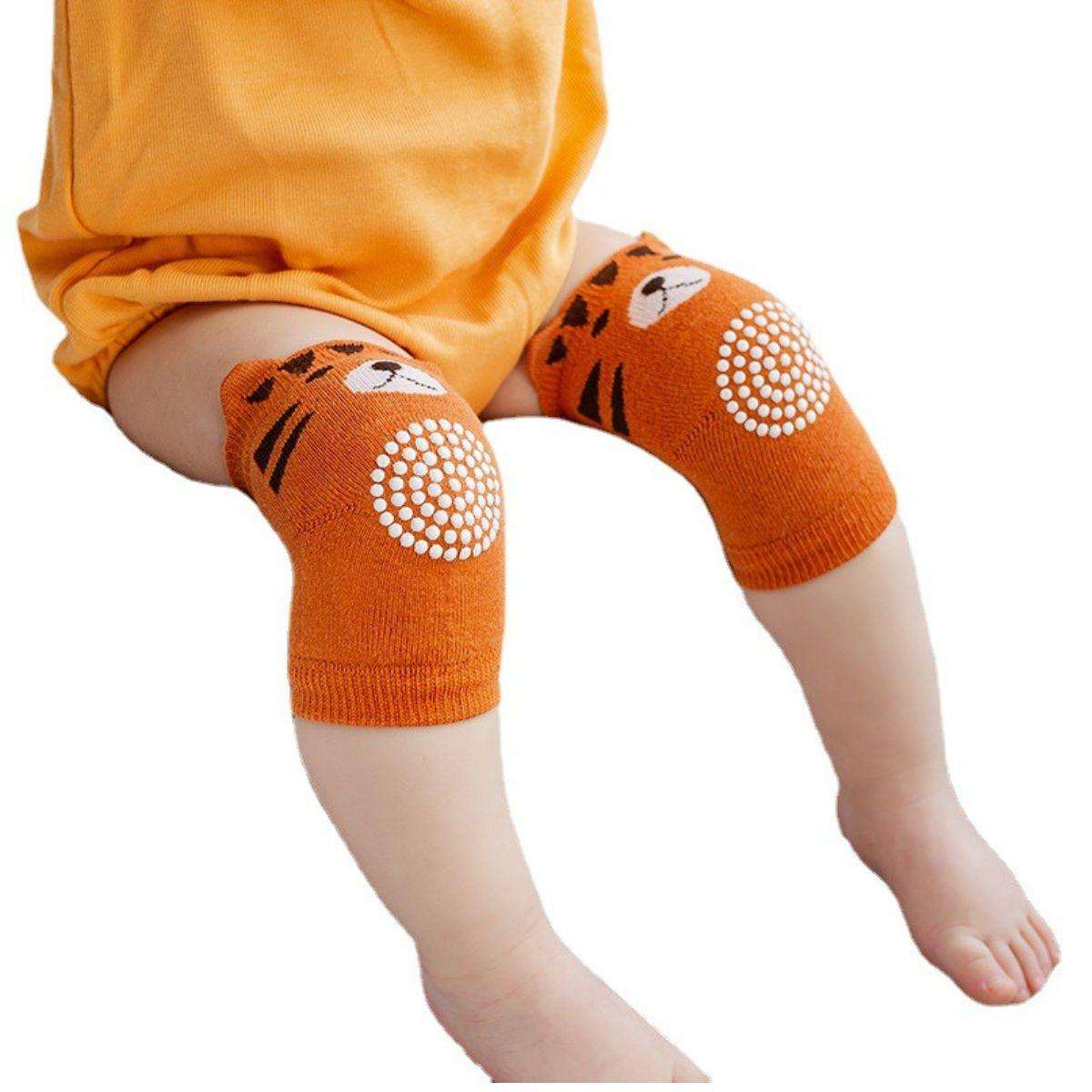 Baby wearing orange Feather & Fawn CrawlGuard anti-slip tiger knee pads for crawling protection