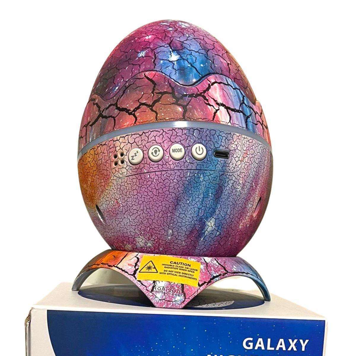 Glowly 4-in-1 Dino Egg Galaxy Projector night light with crackled colorful design on stand and control buttons on front