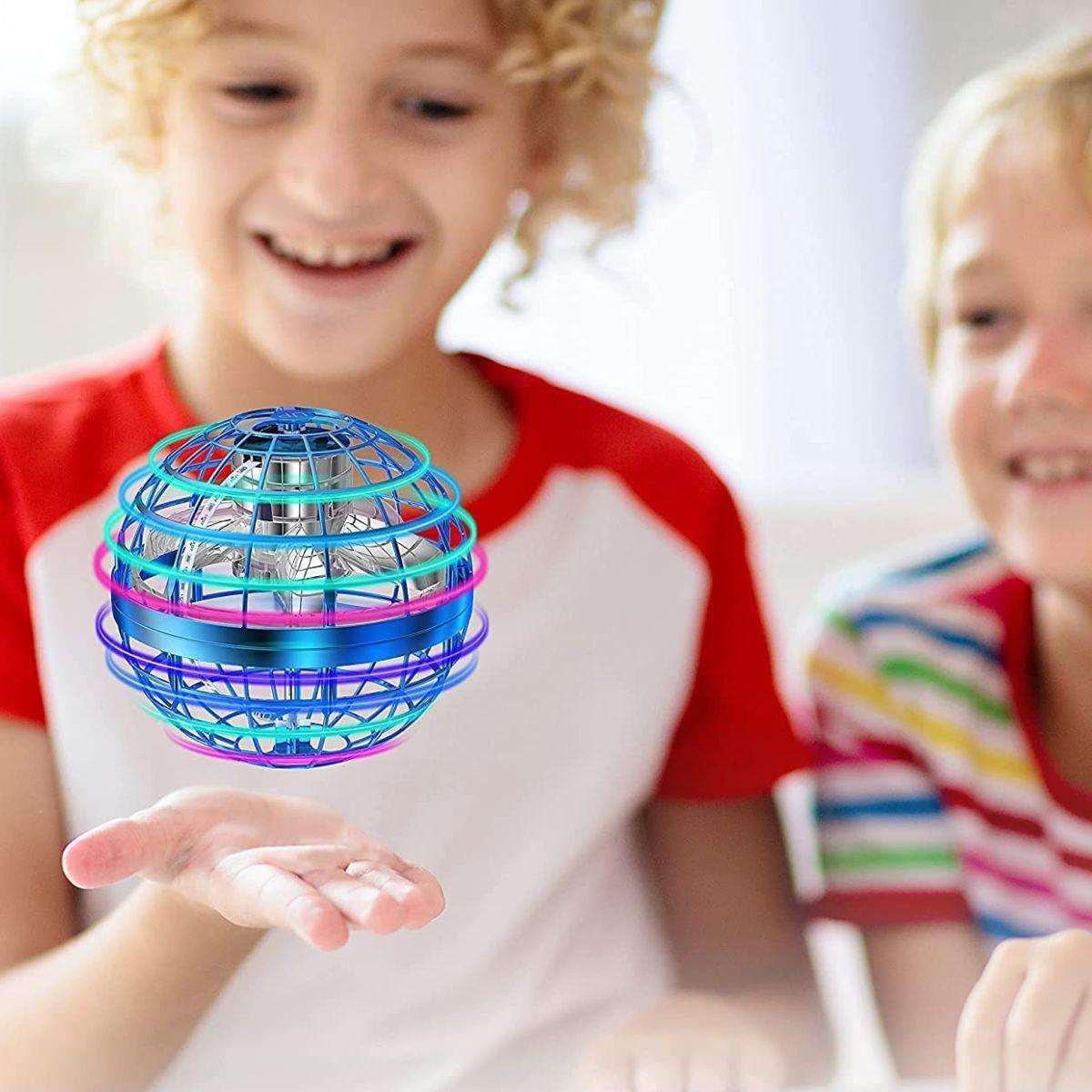 Kidst flying drone hovering orb toy with RGB light held by smiling child