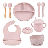 Toddly MealMate silicone feeding set with suction plate, bowl, wooden utensils, cups, and bib for baby-led weaning and self-feeding.